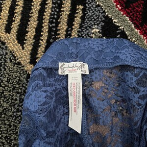 Pode incluir: Um top de renda azul com uma etiqueta branca que diz "Free People" e "Keep Away From Fire".