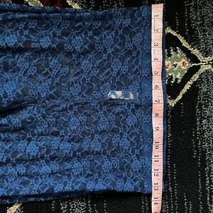 Pode incluir: Tecido de renda azul com padr&atilde;o floral. O tecido &eacute; medido com uma r&eacute;gua, mostrando um comprimento de 35,5 cm.