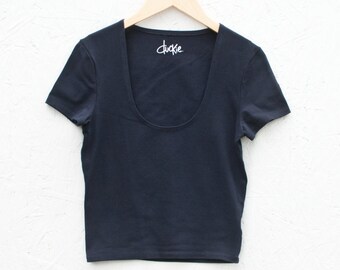Könnte beinhalten: Ein dunkelblaues, kurzärmeliges T-Shirt mit Rundhalsausschnitt und dem Aufdruck "duckie" auf der Vorderseite.