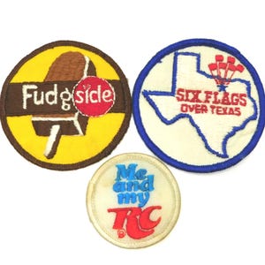 May include: Three vintage embroidered patches. One features a Fudgesicle ice cream bar, another displays the Texas outline with "Six Flags Over Texas" text, and the third says "Me and my RC". Each patch has a different color scheme.