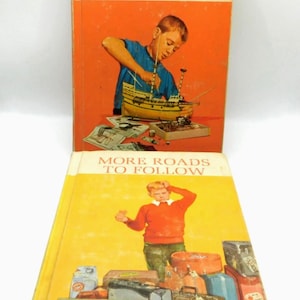 May include: Two vintage children's books titled "Roads to Follow" and "More Roads to Follow." The first book has an orange cover with a boy building a model ship. The second book has a yellow cover with a boy standing in front of luggage.