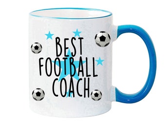 Op de afbeelding: Witte keramische mok met een blauwe rand en handvat. De mok heeft een blauwe ster en de tekst "BEST FOOTBALL COACH" met zwarte voetballen rond de tekst.