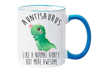 May include: White ceramic mug with a blue rim and handle. The mug features a green dinosaur with a pink butterfly and the text "AUNTISAURUS LIKE A NORMAL AUNTY, BUT MORE AWESOME".