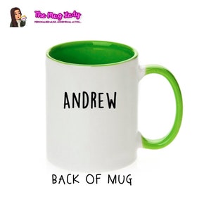May include: White ceramic mug with a green rim and handle. The mug has the name "ANDREW" printed on the front in black.