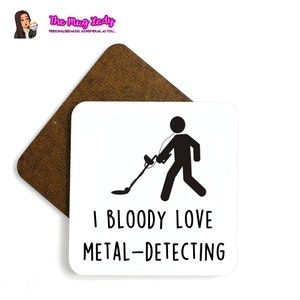 May include: White square coaster with a black stick figure holding a metal detector. The text "I BLOODY LOVE METAL-DETECTING" is printed in black below the figure.