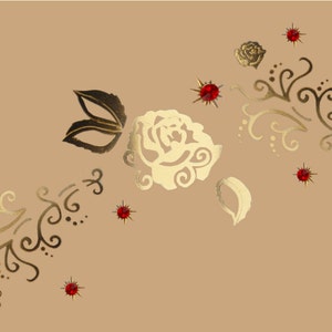 May include: Gold-colored rose and floral design with red rhinestone accents. The design is on a light brown background.