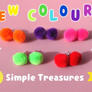 Könnte beinhalten: Eine Auswahl an bunten Pompon-Ohrringen in Orange, Lila, Pink, Grün und Rot. Der Text "NEW COLOURS" und "Simple Treasures" ist auf einem rosa Hintergrund mit Sternen und einem Smiley abgebildet.