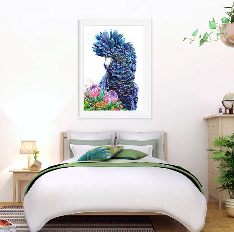 Puede incluir: Una pintura de acuarela de un cacat&uacute;a negro con plumaje azul y verde, posado entre flores de protea rosas y verdes. El p&aacute;jaro est&aacute; mirando hacia la izquierda de la imagen.