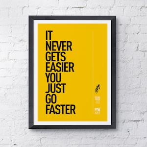 Puede incluir: Un póster motivacional amarillo con texto negro que dice "It never gets easier you just go faster". El póster también presenta una pequeña ilustración en blanco y negro de un ciclista y el texto "Cycling Widow 2021" y "PTW ART".