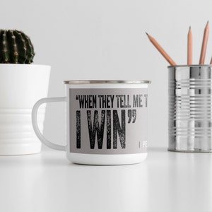 May include: White enamel camping mug with a grey background and black text that reads "When they tell me to, I win".