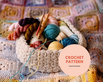 Op de afbeelding: Een beige gehaakte mand gevuld met kleurrijke garen strengen, houten haaknaalden en een houten spoel. De mand staat op een veelkleurige gehaakte deken. Tekst op de afbeelding luidt "CROCHET PATTERN" en "Instant Download."