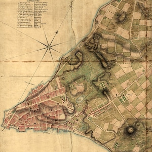 Op de afbeelding: Een vintage kaart van een kuststad, met gedetailleerde stratenplannen, gebouwen en groene ruimtes. De kaart bevat een kompasroos en een lijst met referenties. Het kleurenpalet is een mix van bruin, rood en groen, met zwarte tekst.