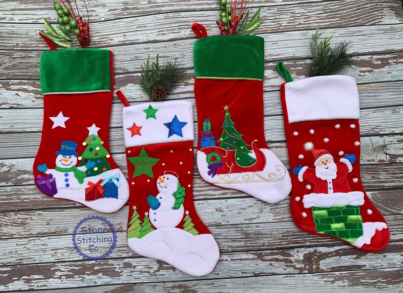 May include: Four red Christmas stockings with various designs. One features a snowman, Christmas tree, and presents. Another has a snowman with stars. The third has a Christmas tree on a sleigh. The last has Santa Claus in a chimney. Each has a green cuff.
