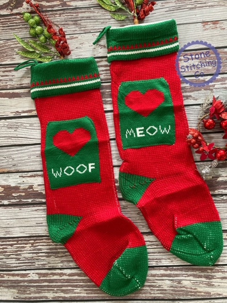 May include: Two red and green knitted Christmas stockings with a heart and the words "WOOF" and "MEOW" on them.