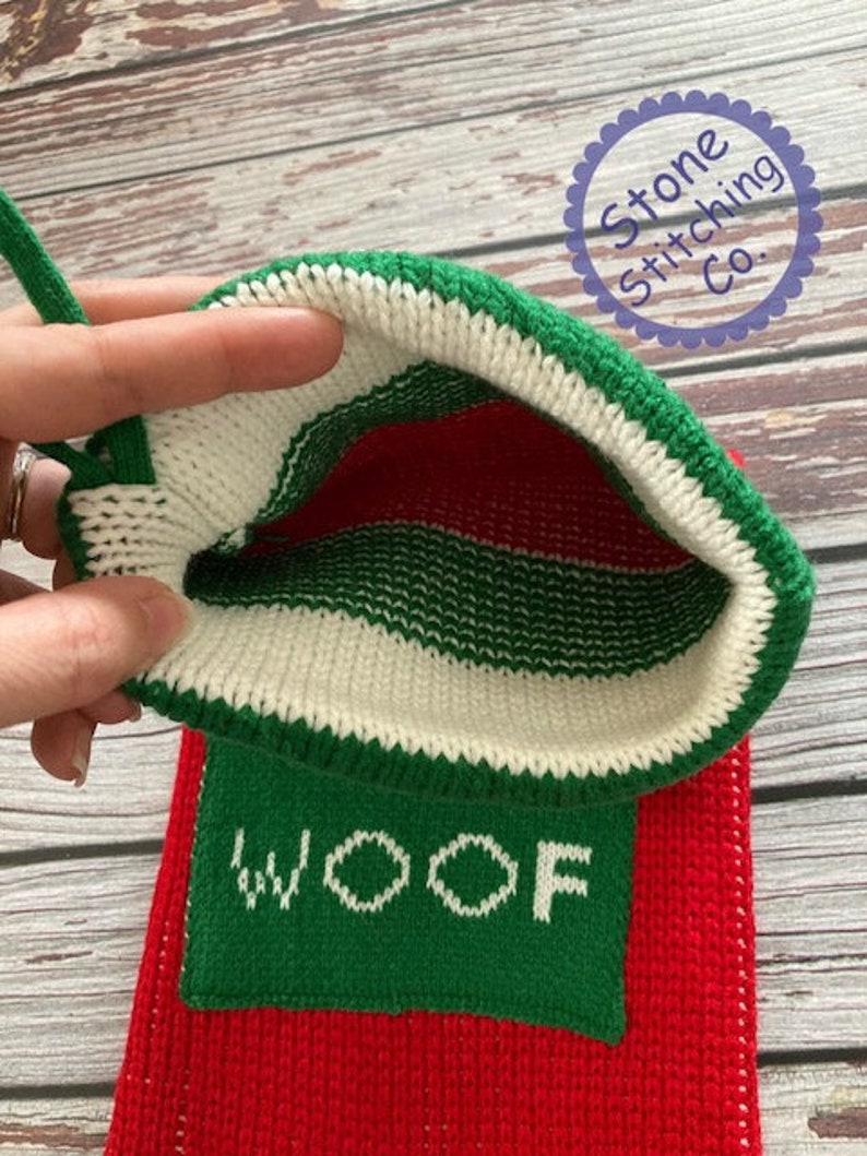 May include: Red and green knitted stocking with a white cuff and the word "WOOF" embroidered in white on a green background. The stocking is turned inside out to show the knit pattern.
