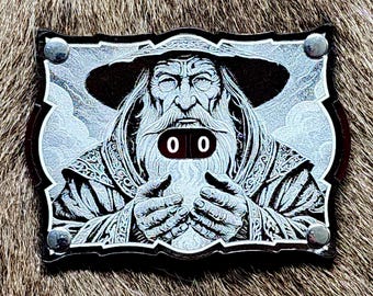 May include: A black and white illustration of a wizard with a long white beard holding a glowing orb. The wizard is wearing a pointed hat and a long robe. The image is framed in a black and silver border with two silver rivets on each side. The image has the numbers "00" in a red box in the center.