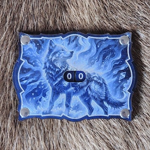 May include: A blue and white game piece with a wolf illustration. The wolf is depicted amidst swirling blue designs, with the number "00" visible. The piece has a decorative border and silver rivets.
