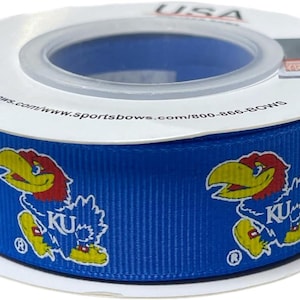 Op de afbeelding: Een rol blauw lint met de mascotte van de Kansas Jayhawks, een cartoon Jayhawk. Het lint heeft een herhalend patroon van het Jayhawk-logo met de letters "KU". De rol is wit met de tekst "USA" erop gedrukt.