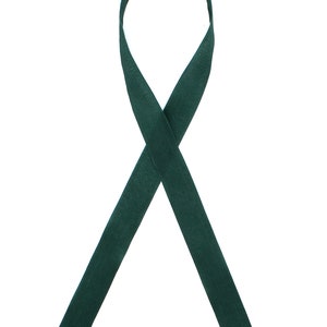 May include: A dark green ribbon tied in a bow.