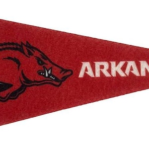 May include: Red pennant with a black vertical stripe on the left side. The pennant features a white wordmark "ARKANSAS" and a black and white illustration of a Razorback hog.