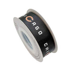 Pode incluir: Um carretel de fita gorgorão preta com o texto branco repetido CHICAGO e uma letra C laranja. A fita é enrolada em torno de um núcleo de plástico branco, exibindo uma superfície texturizada e canelada em todo o material.