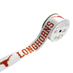 May include: A white ribbon with the word "Longhorns" printed in orange. The ribbon is rolled up on a spool with a white label that says "Officially Licensed Product".