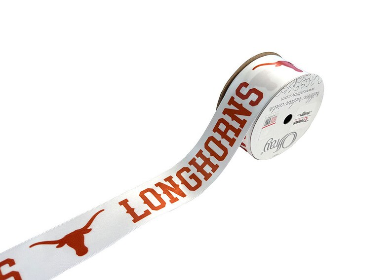 May include: A white ribbon with the word "Longhorns" printed in orange. The ribbon is rolled up on a spool with a white label that says "Officially Licensed Product".