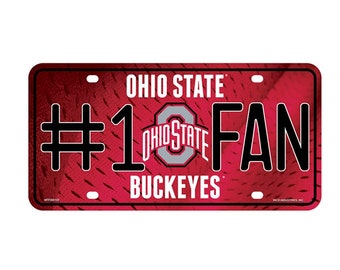 May include: A red and white Ohio State Buckeyes licence plate with the text "#1 FAN" and the Ohio State logo.