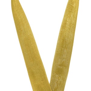 May include: A gold ribbon with a textured surface. The ribbon is folded in a V-shape.