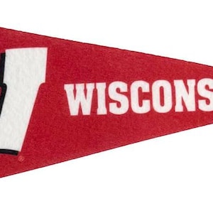 Op de afbeelding: Rode wimpel met het woord "WISCONSIN" in witte blokletters. Een groot wit "W"-logo staat aan de linkerkant. Een zwarte streep loopt langs de linkerrand. Deze wimpel is waarschijnlijk een souvenir of een decoratief item.