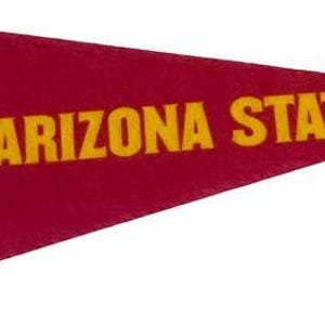 Puede incluir: Bandera triangular granate con las palabras "ARIZONA STATE" en letras doradas. Un logotipo de tridente dorado está en el lado izquierdo. Una franja negra recorre verticalmente el borde izquierdo. La bandera tiene forma triangular.