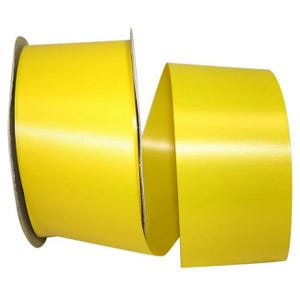 May include: A wide, solid yellow ribbon wound around a cardboard spool. The ribbon features a smooth, satin-like texture with a consistent, vibrant yellow color throughout its length, displaying a slight sheen across the surface of the material.
