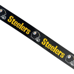May include: Black and yellow ribbon with the word "Steelers" repeated and a football helmet graphic.
