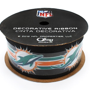 May include: A roll of black and teal decorative ribbon with a Miami Dolphins logo and the text "DECORATIVE RIBBON CINTA DECORATIVA &copy; 2012 NFL PROPERTIES, LLC Offray www.offray.com"