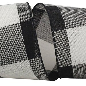 May include: A wide spool of fabric ribbon featuring a bold black and white buffalo check pattern. The ribbon has a textured, woven appearance with a consistent grid design of alternating black and white squares throughout the entire length.