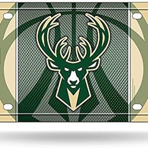May include: Green and white metal license plate featuring the Milwaukee Bucks logo. The logo is a green deer head with antlers, a basketball, and the word "Bucks" on either side.