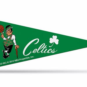May include: Green pennant with a white shamrock and the word "Celtics" in white script. A cartoon mascot wearing a green and white outfit holds a basketball and a walking stick. The text "RICO INC./© 2015 NBA Properties, Inc." is at the bottom.
