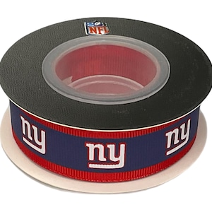 Könnte beinhalten: Eine Rolle Ripsband mit dem Logo der New York Giants, bestehend aus weißen ny-Buchstaben auf dunkelblauem Grund, umrandet von roten Streifen. Die Oberseite der Rolle ist schwarz und trägt einen mittigen NFL-Logoaufkleber auf dem Kunststoffkern.