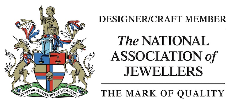 Op de afbeelding: Een logo voor The National Association of Jewellers, met een wapenschild met twee eenhoorns, een schild met een leeuw en de tekst "CONCORDIA-INTEGRITAS INDUSTRIA". De tekst "DESIGNER/CRAFT MEMBER" en "THE MARK OF QUALITY" zijn ook opgenomen.