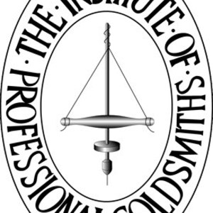 Op de afbeelding: Zwart-wit logo van The Institute of Professional Goldsmiths. Het logo is een ovaal met de tekst "The Institute of Professional Goldsmiths" rond de rand. Binnen het ovaal is een zwart-witte illustratie van een boormachine.