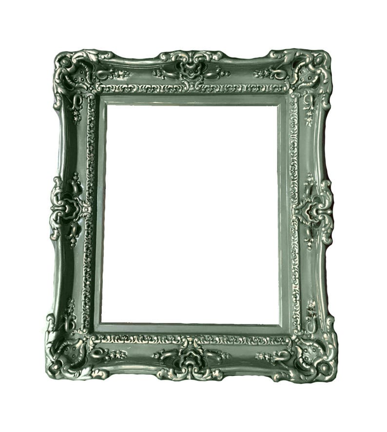 May include: A silver-colored ornate picture frame with a decorative, detailed design. The frame is made of wood and has a smooth, glossy finish.