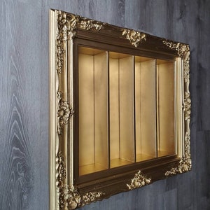May include: An ornate picture frame in a gold colour with four compartments. The frame is made of wood and has a distressed finish. The compartments are empty.
