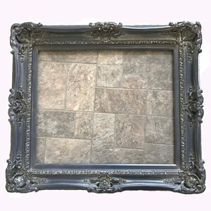 May include: A black ornate picture frame with a decorative design. The frame is empty and ready for a picture.