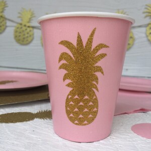 May include: Pink paper cup with a gold glitter pineapple design. The cup is perfect for a tropical themed party.