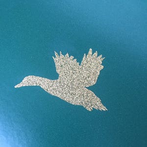 May include: A teal blue plate with a silver glitter duck silhouette.