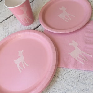 May include: Pink paper plates and cups with a white deer silhouette design. The plates are 9 inches in diameter.