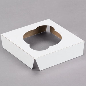 May include: White cardboard cupcake box with a round cutout in the center. The box is designed to hold a single cupcake.