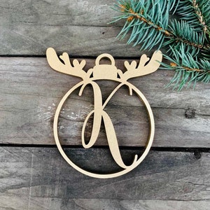 Peut inclure: Ornement de Noël en bois en forme de renne avec un cercle pour l'ornement et la lettre K au centre.