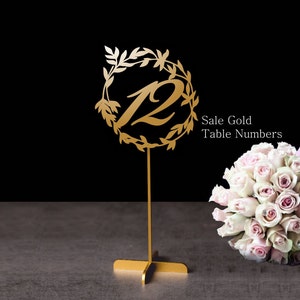 May include: Gold table number with a floral design and the number 12. The table number is on a gold stand. Sale Gold Table Numbers.