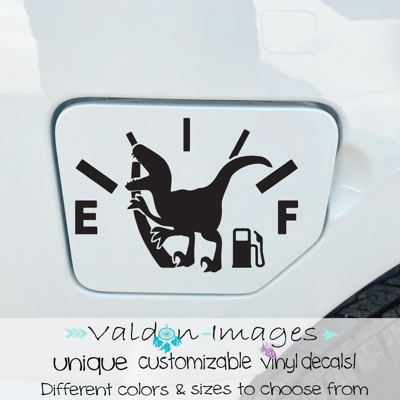 May include: A black and white vinyl decal of a dinosaur silhouette with a gas pump in its mouth, placed over a gas gauge graphic. The gauge reads "E" for empty and "F" for full. The decal is designed to be placed on a car's gas tank door.